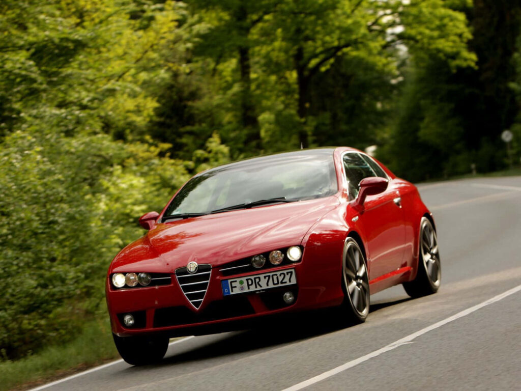 Alfa Romeo Brera sports car driving on scenic road with lush green surroundings and sleek design Wallpaper