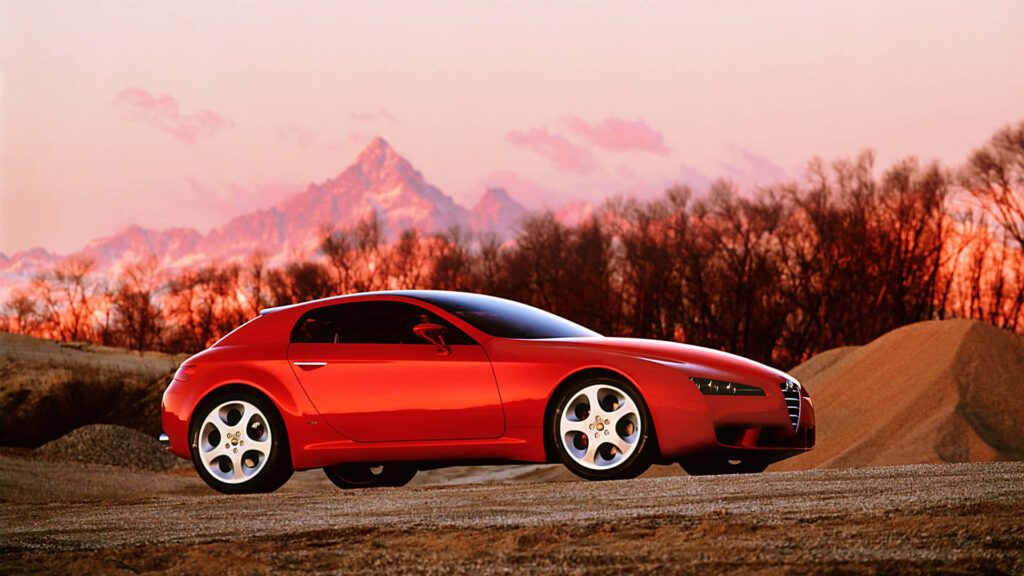 Alfa Romeo Brera car against vibrant mountain sunset high-resolution wallpaper background