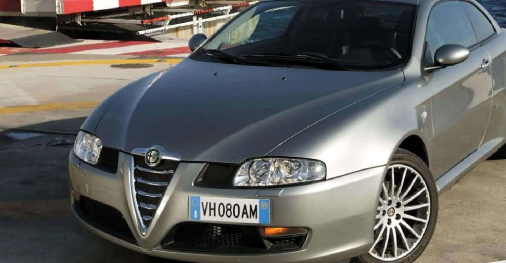 Alfa Romeo GT sleek design shining under sunlight on street showcasing signature grille wallpaper