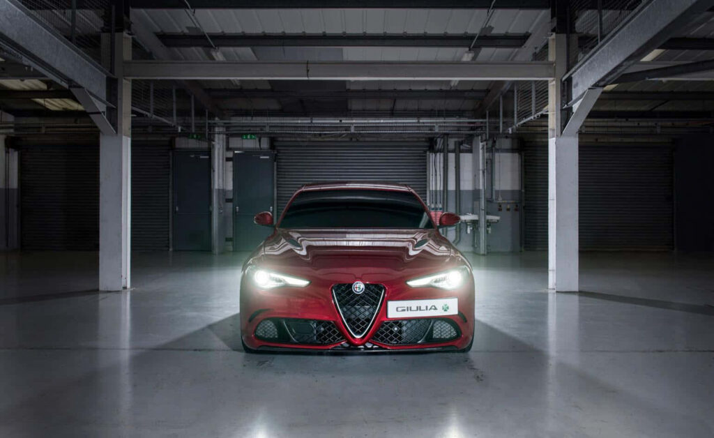Alfa Romeo Giulia front view indoors with bold design dramatic lighting wallpaper background