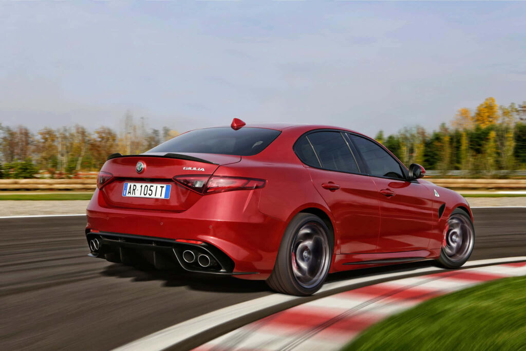 Alfa Romeo Giulia speeding on racetrack sleek sporty design dynamic performance wallpaper