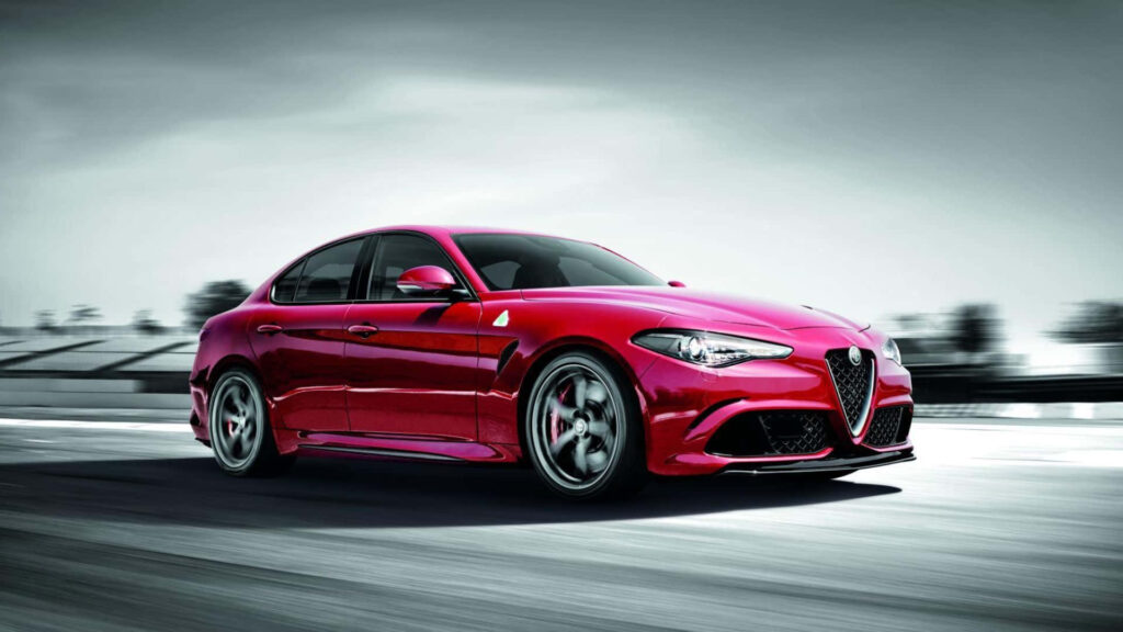 Alfa Romeo Giulia speeding through vibrant cityscape showcasing sleek design dynamic presence Wallpaper