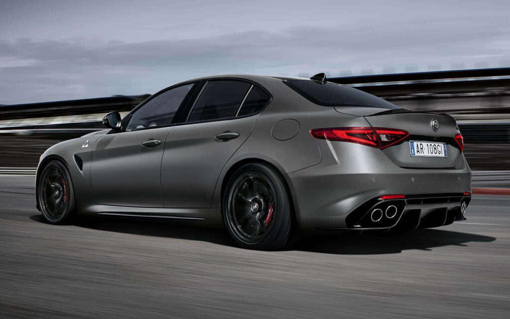 Alfa Romeo Giulia speeding on road dynamic design sporty performance action wallpaper background