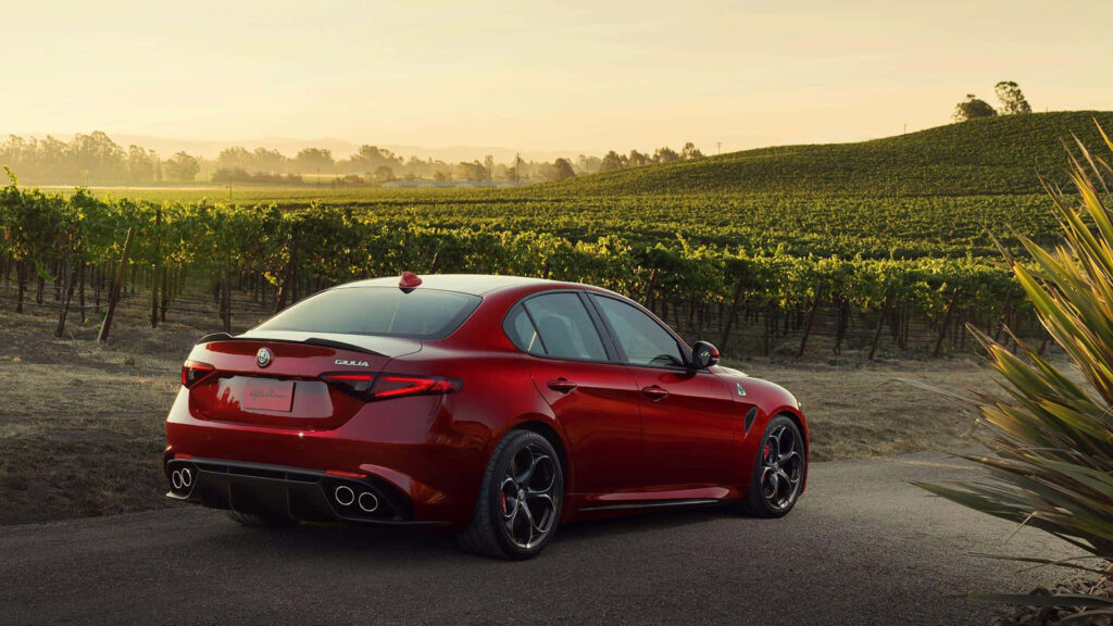 Alfa Romeo Giulia on scenic country road sunset elegant design dynamic performance wallpaper