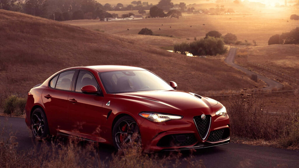 Alfa Romeo Giulia parked on winding countryside road at sunset luxury car performance wallpaper