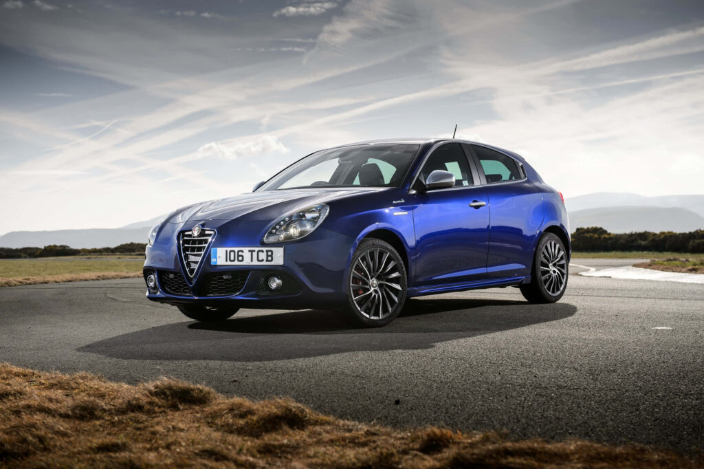 Alfa Romeo Giulietta vibrant blue sporty car parked on scenic road under dramatic sky wallpaper