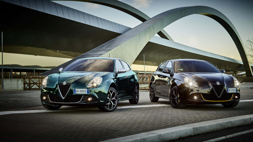 Two sleek Alfa Romeo Giulietta cars parked side by side with modern design and architecture background Wallpaper