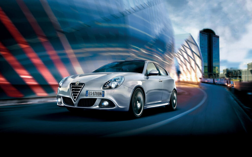 Alfa Romeo Giulietta speeding on scenic countryside road dynamic Italian car wallpaper background