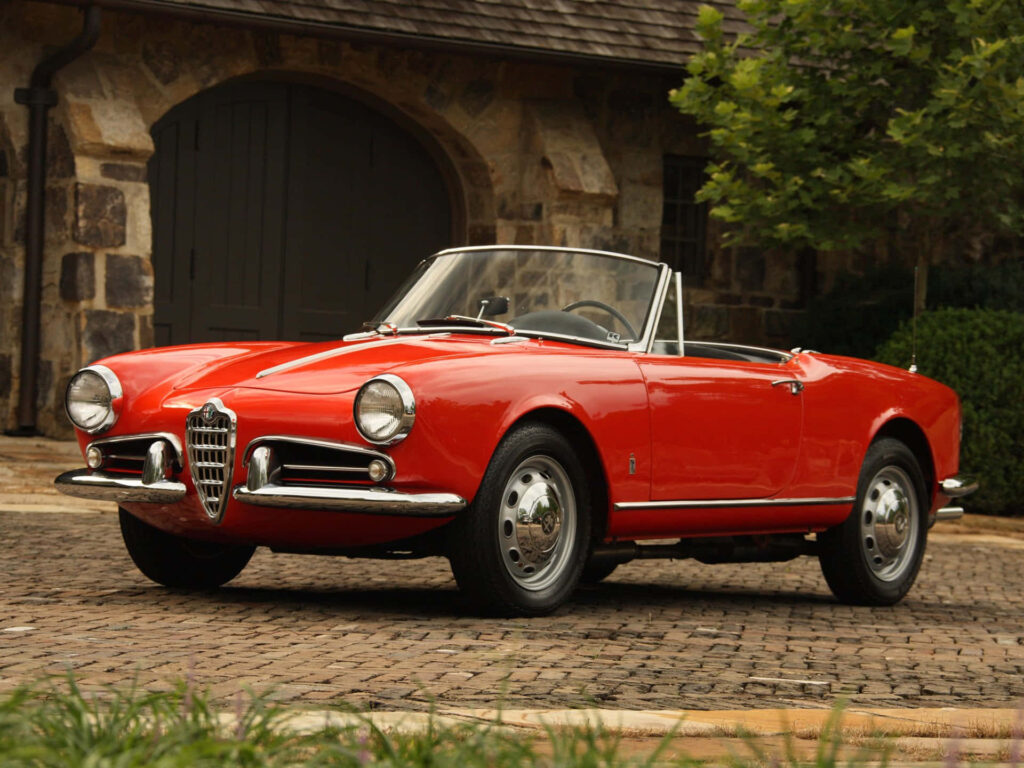 Alfa Romeo Spider red convertible classic Italian design on rustic stone driveway wallpaper background