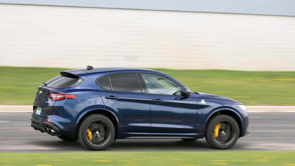 Alfa Romeo Stelvio luxury SUV speeding on scenic highway vibrant outdoor driving wallpaper