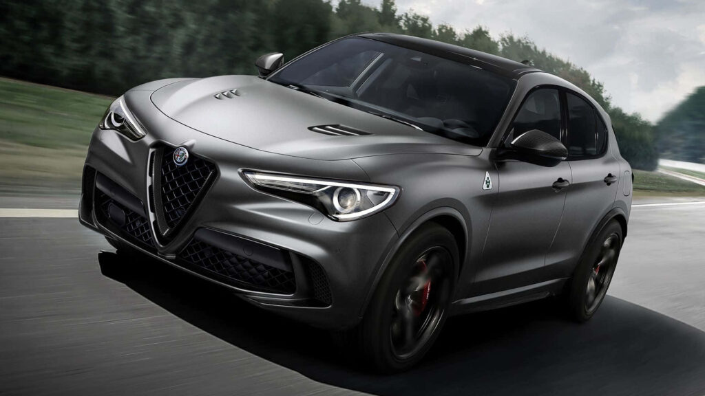 Alfa Romeo Stelvio speeding on winding mountain road with sporty design and scenic backdrop wallpaper