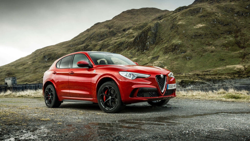 Alfa Romeo Stelvio SUV parked in rugged mountains showcasing sporty design and adventure spirit Wallpaper