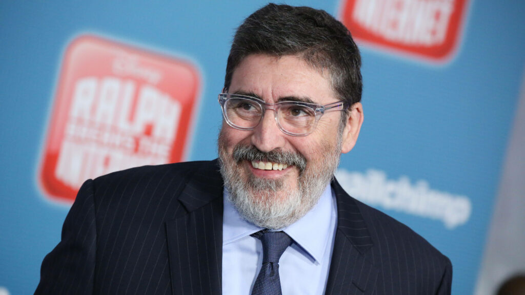 Alfred Molina smiling at Ralph Breaks The Internet premiere with animated film logo backdrop Wallpaper