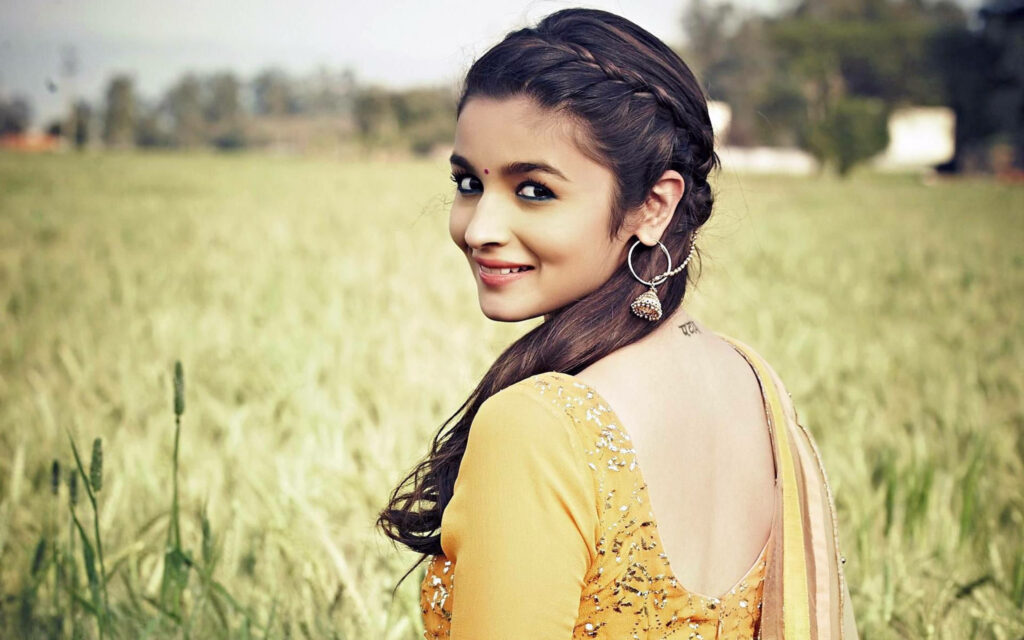 Alia Bhatt in traditional outfit with braid smiling in sunlit field Humpty Sharma character wallpaper