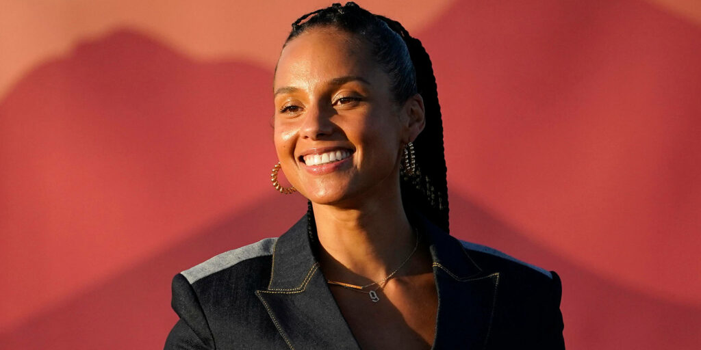 Alicia Keys smiling confidently against a vibrant colorful background wallpaper radiating positivity