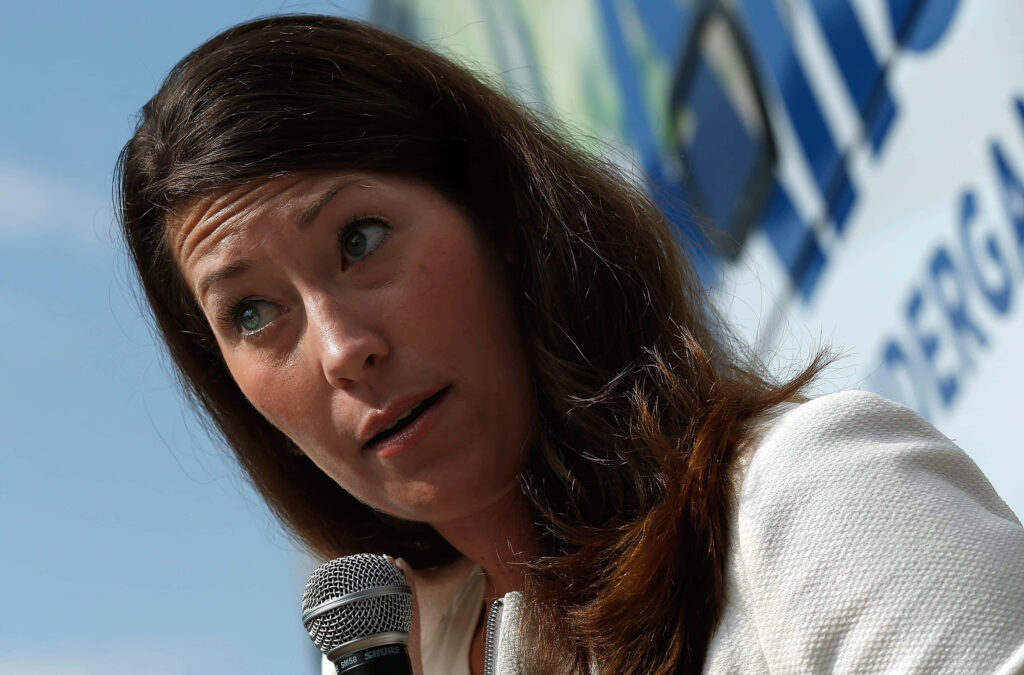 Alison Lundergan Grimes speaking into microphone outdoors with skeptical expression wallpaper background