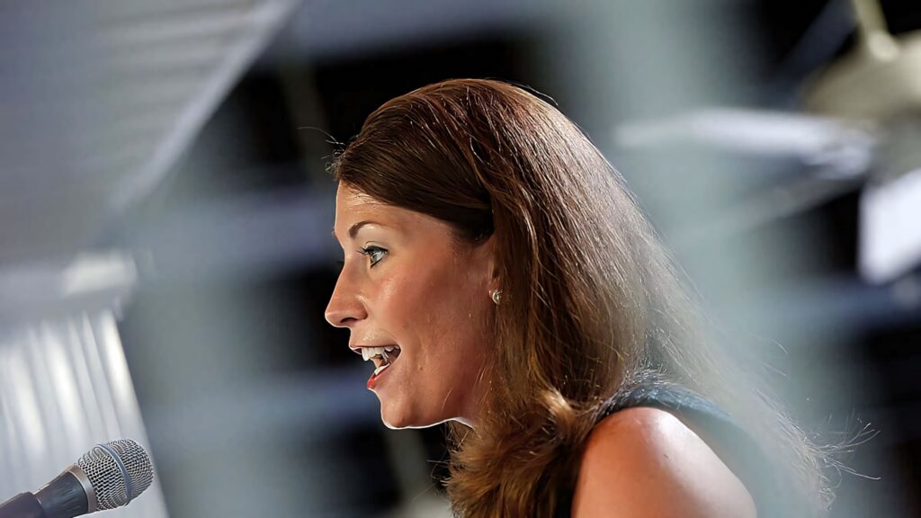 Alison Lundergan Grimes speaking passionately into microphone with dramatic lighting close-up Wallpaper