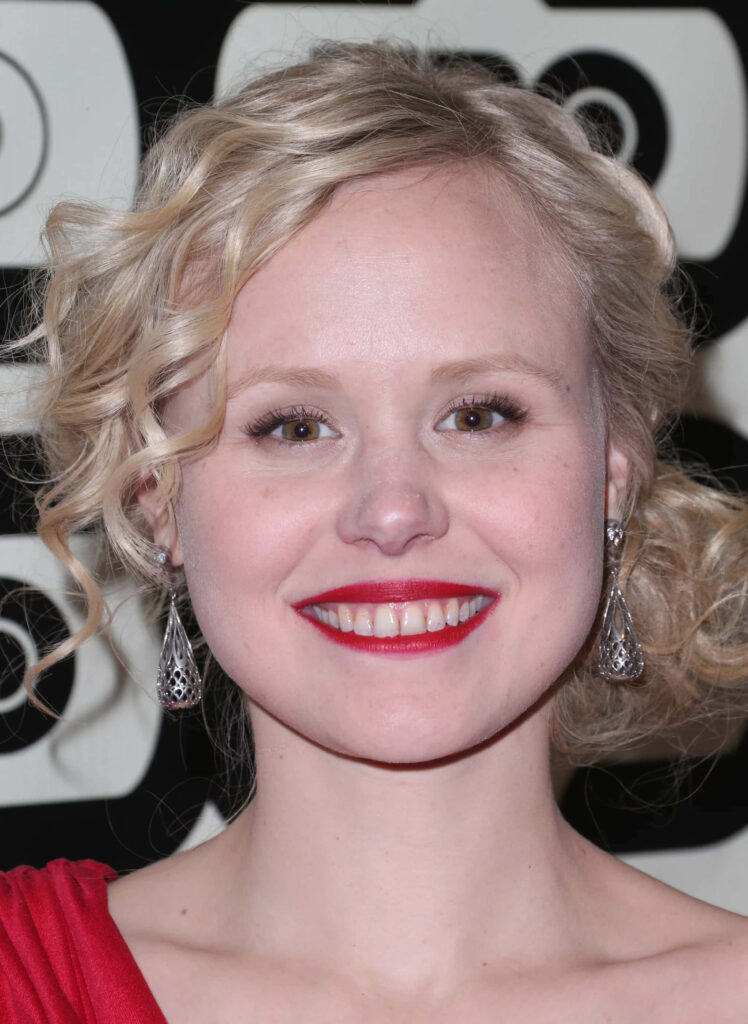 Alison Pill smiling brightly in vibrant wallpaper showcasing elegant style and cheerful expression