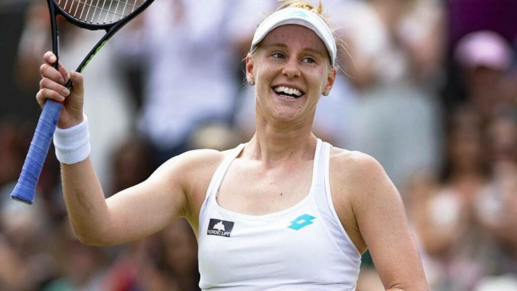 Alison Riske-Amritraj smiling joyfully raising tennis racket on court wallpaper background