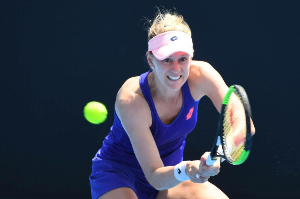 Alison Riske-Amritraj in blue tennis outfit focused preparing to hit ball dark background wallpaper