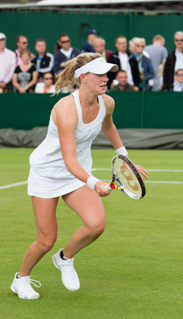 Alison Riske-Amritraj playing intense tennis match on grass court showing focus and skill Wallpaper