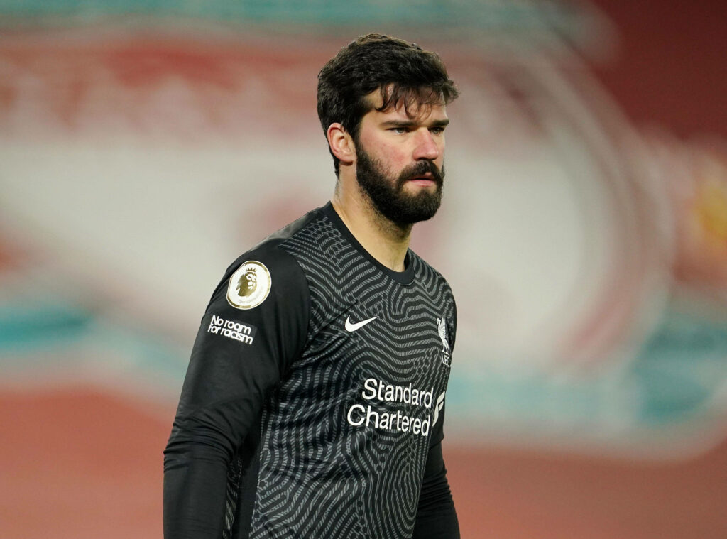 Alisson Becker focused in black Liverpool goalkeeper jersey showing determination on field wallpaper