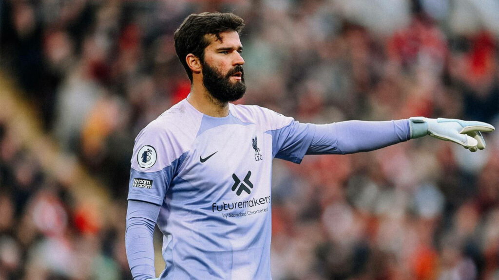 Alisson Becker in Liverpool goalkeeper kit pointing and directing team during match wallpaper