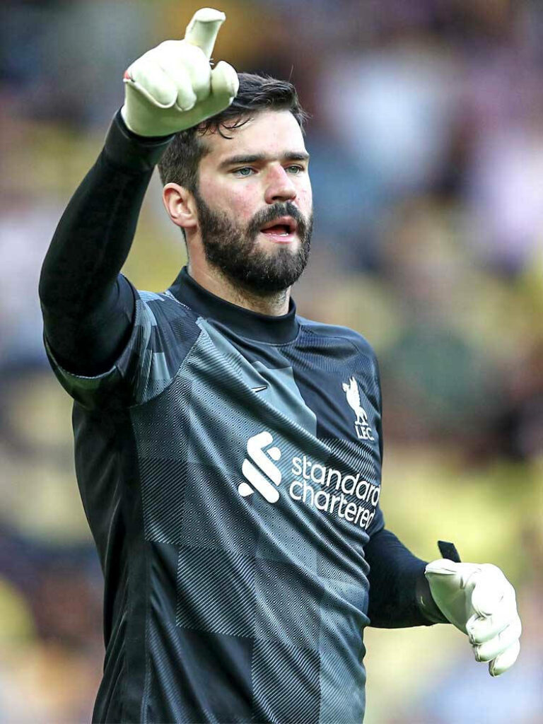 Alisson Becker Liverpool goalkeeper kit pointing assertively football match leadership focus Wallpaper