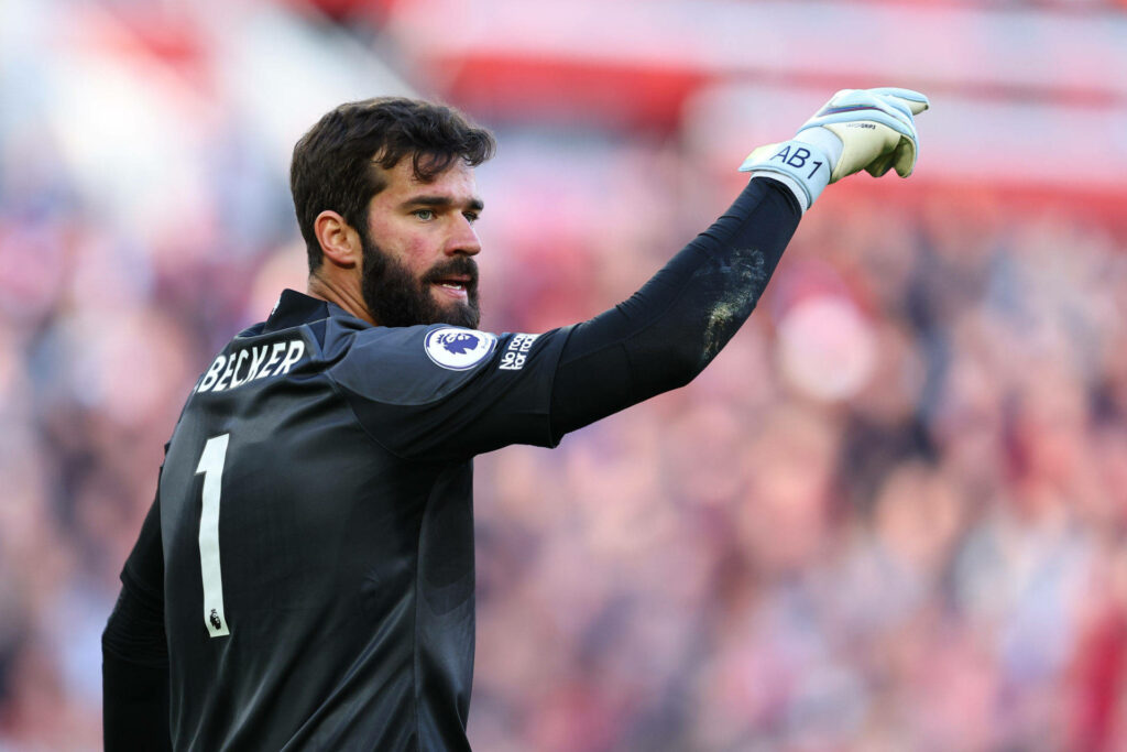 Alisson Becker in Liverpool number 1 jersey confidently directing team on field dynamic wallpaper