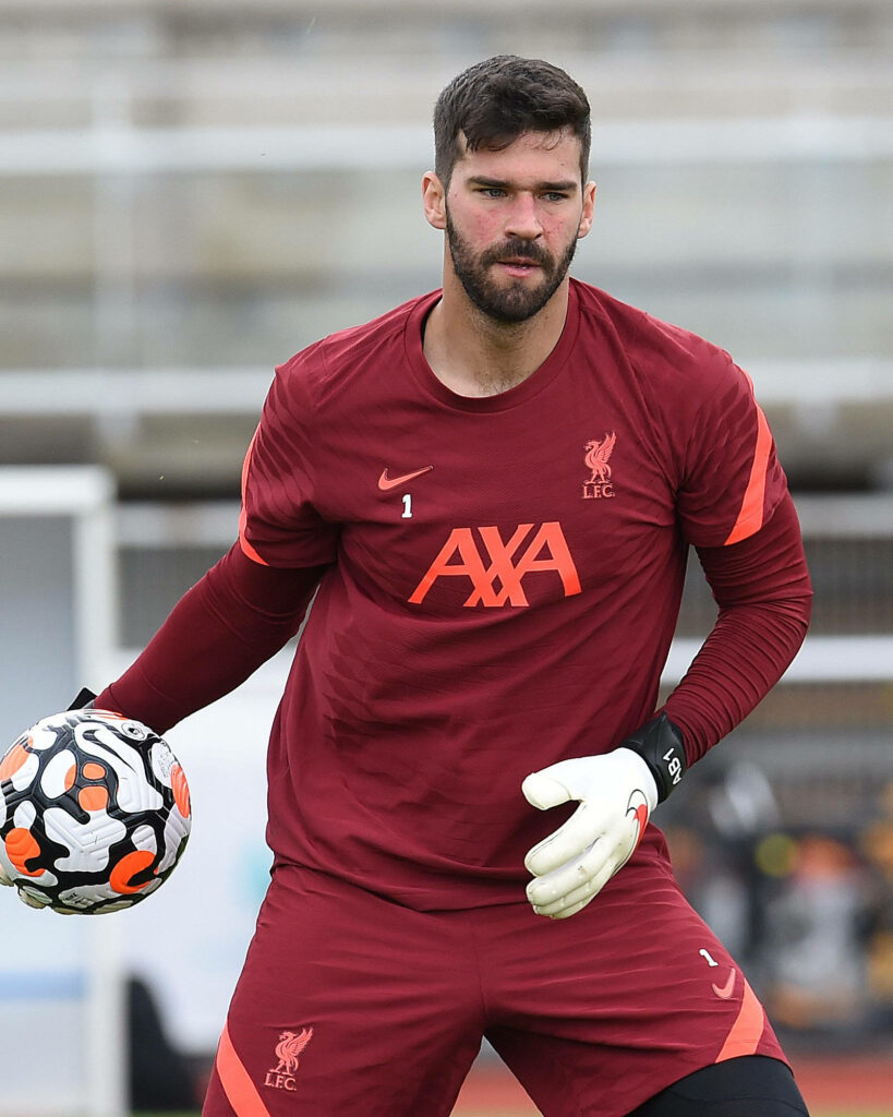 Alisson Becker Liverpool training kit holding soccer ball ready for action on the field wallpaper
