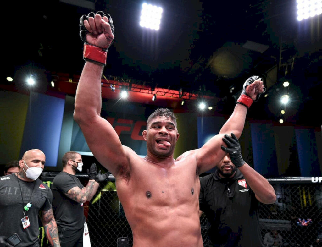 Alistair Overeem celebrating UFC victory in octagon with arms raised wallpaper background