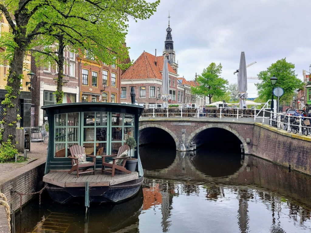 Charming Alkmaar canal with historic bridge and old buildings under a peaceful sky wallpaper