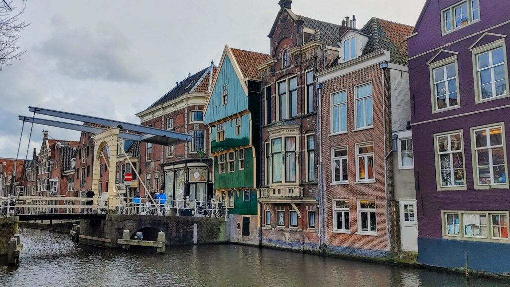 Scenic Alkmaar canal with colorful Dutch houses and charming historic bridge waterside view Wallpaper