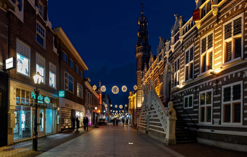 Night street view Alkmaar Netherlands with illuminated historic buildings warm inviting lights Wallpaper