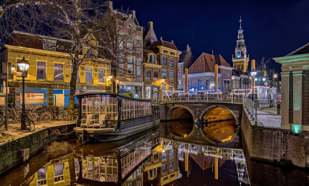 Enchanting night view of Alkmaar Netherlands with historic buildings canal and glowing streetlights Wallpaper