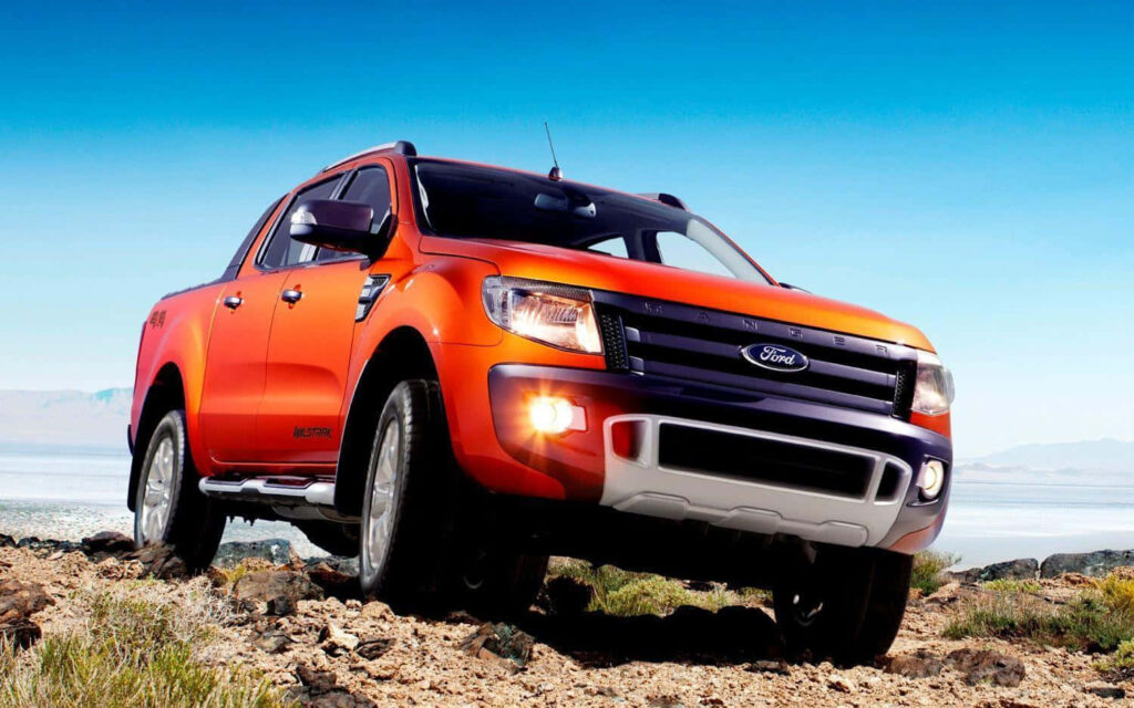All-New Ford Ranger pickup truck driving rugged terrain with bold design under clear blue sky Wallpaper