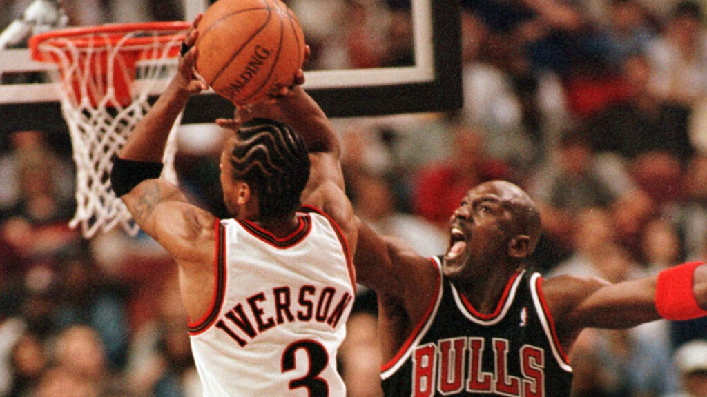 Allen Iverson driving to basket against Michael Jordan intense basketball showdown wallpaper background