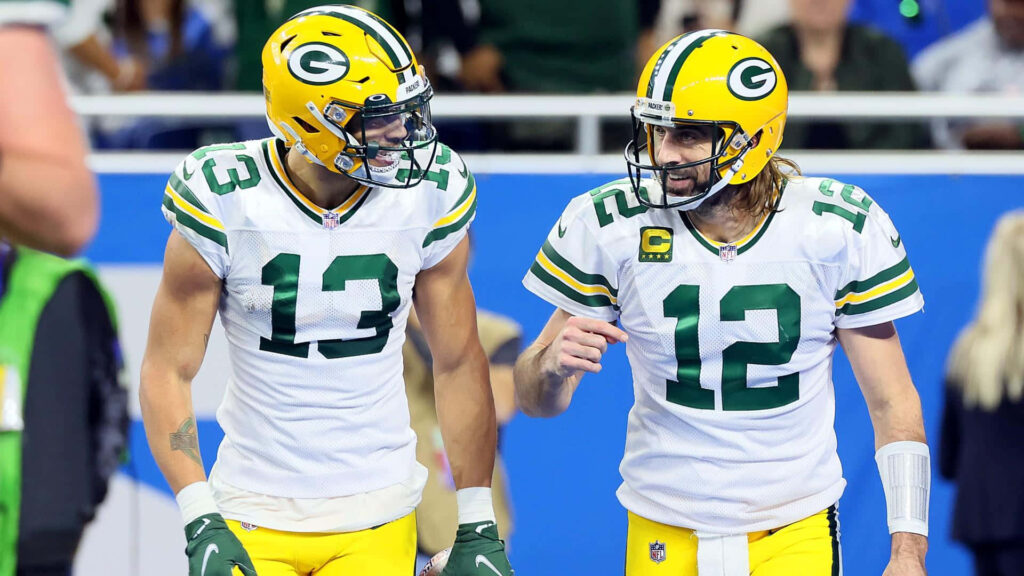Allen Lazard and Green Bay Packers teammate in white green uniforms talking on field during game Wallpaper