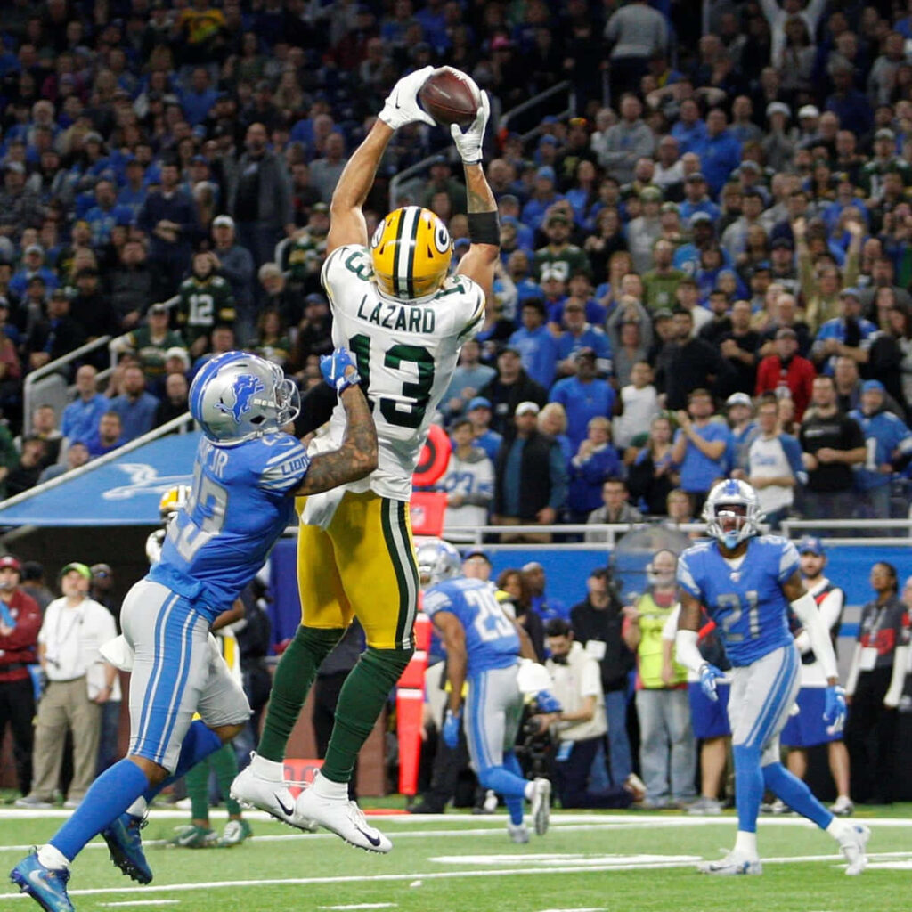 Allen Lazard leaps for a spectacular football catch displaying athleticism in a packed stadium Wallpaper