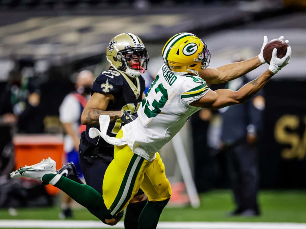 Allen Lazard leaps to make a dynamic football catch defending against a close opponent wallpaper background