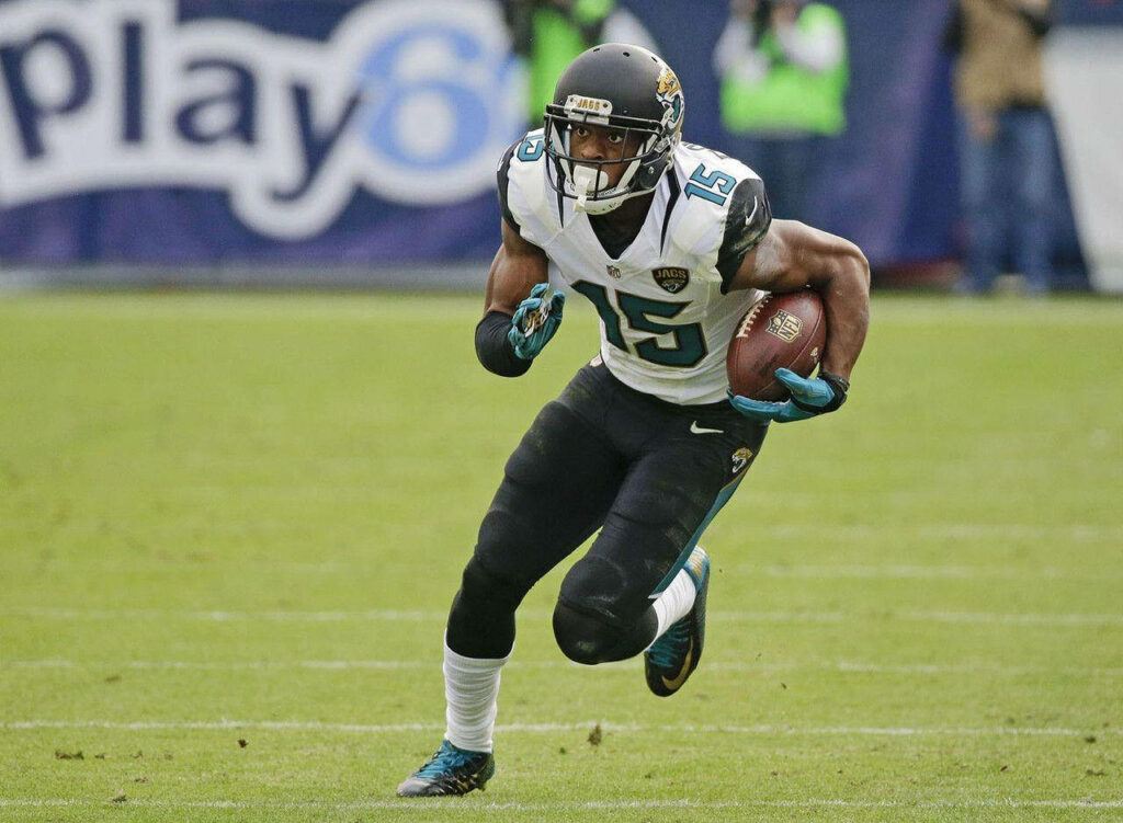 Allen Robinson running with football in Jacksonville Jaguars uniform during NFL game action Wallpaper