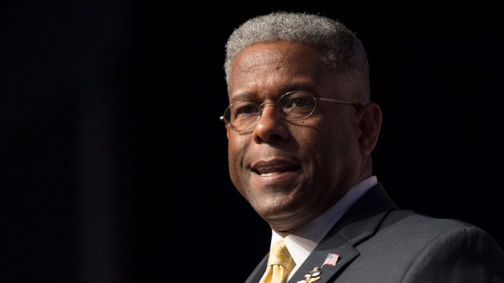 Allen West American leader close-up portrait in suit with flag pin on dark background wallpaper
