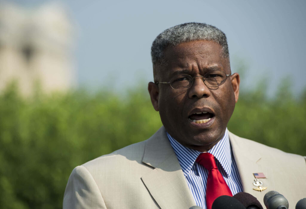 Allen West speaking in open green field with blue sky background wallpaper for presentation