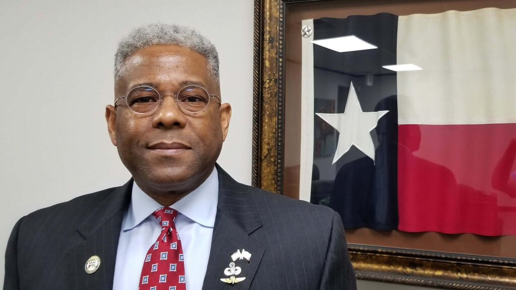 Allen West standing confidently with Texas State Flag background symbolizing Texas leadership Wallpaper