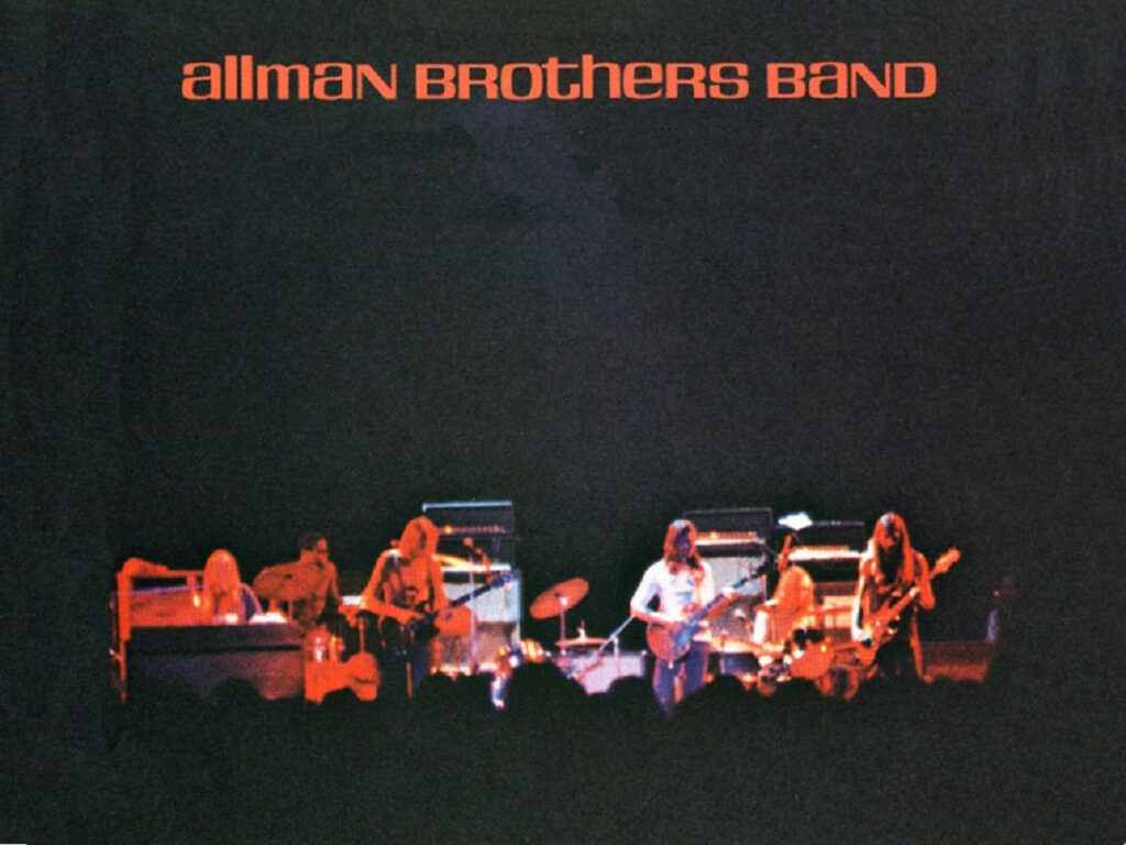 Allman Brothers Band live performance vibrant concert stage with instruments and lighting wallpaper