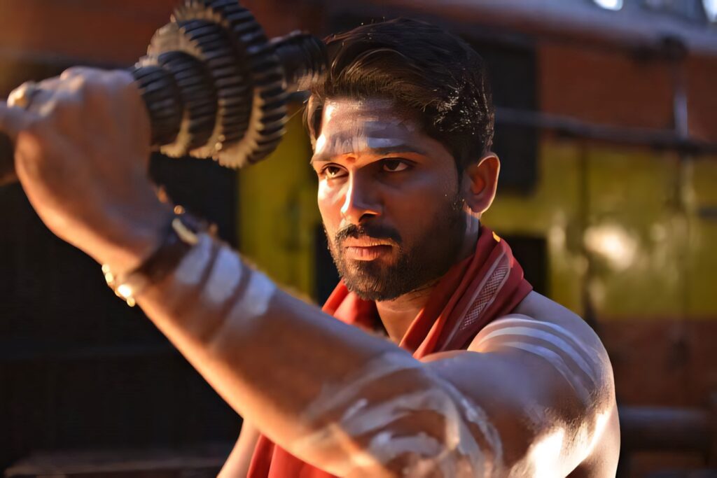 Allu Arjun shirtless with white paint marks holding metallic object bold intense wallpaper background