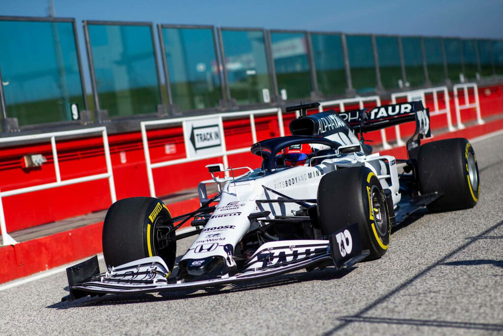 AlphaTauri Formula 1 car on sunny racetrack showcasing sleek design and aerodynamics wallpaper