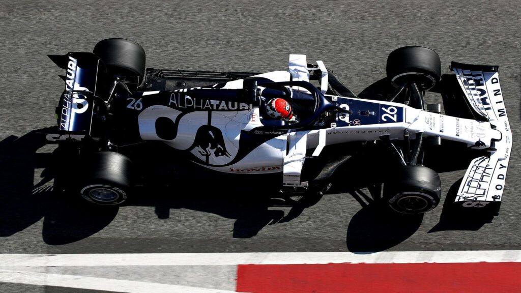 Alphatauri F1 car racing fast on sunny track with white and navy livery motorsport wallpaper