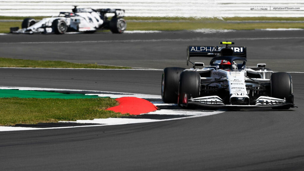Alphatauri Formula 1 car accelerating on a sharp turn at racetrack showcasing speed and precision Wallpaper