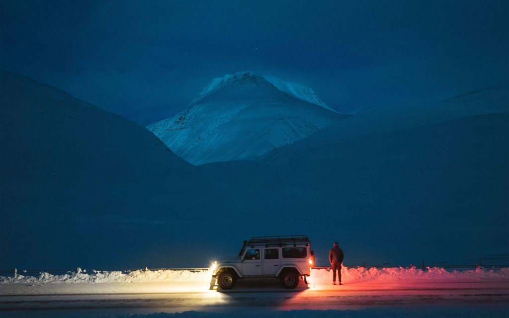 White Land Rover Defender on snowy mountain at twilight alpine adventure wallpaper background